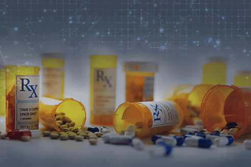 Prescription medication bottles with pills scattered on a surface showcase one of the winning benefits medical carriers can provide.